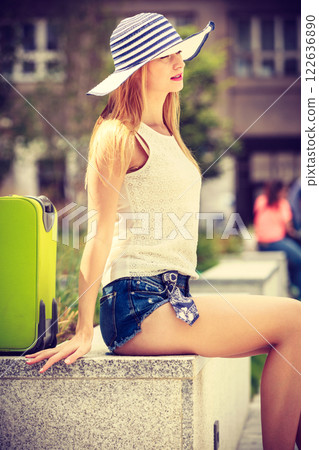 Attractive woman tourist with suitcase relaxing after trip Attractive woman tourist with suitcase relaxing after trip 122636890