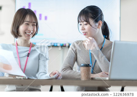 A young businesswoman having a meeting while holding documents 122636978