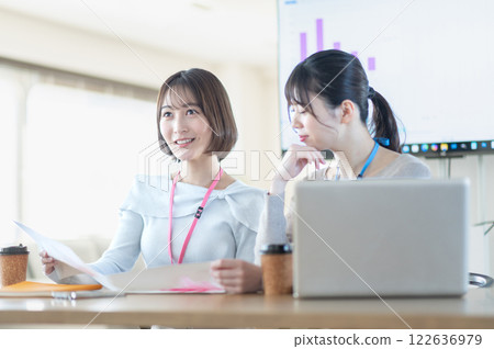 一位年輕女商人一邊拿著文件一邊開會 122636979