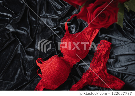 Lace women's red underwear, lingerie and red roses for Valentine's day on dark. Romantic dating. View from above. Copy space. 122637787