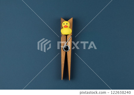 Wooden clothespin and rubber duck signify looming crisis, crisis building from mundane scene, crisis underlining moments when resourceful thinking must overcome blocked possibilities 122638240