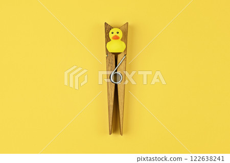 Large clothespin with yellow duck triggers playful prank on April Fool day, prank offering sudden confusion. Prank boosting comedic tension in daily routine for unexpected fun 122638241