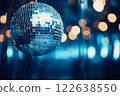 A disco ball is suspended from the ceiling at party, reflecting the lights 122638550
