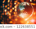 A disco ball is suspended from the ceiling at party, reflecting the lights 122638551