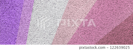 A textured abstract background featuring diagonal color stripes in shades of pink, violet, lavender, and purple with a rough surface finish, creating a vibrant and artistic visual. Long banner. 122639025