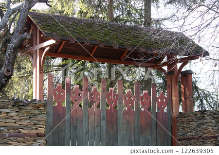 Decorative wooden gate with stylized human faces Decorative wooden gate with stylized human faces 122639305