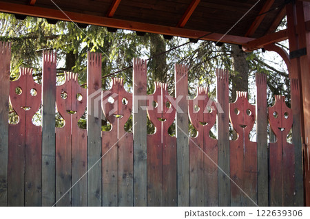 Decorative wooden gate with stylized human faces Decorative wooden gate with stylized human faces 122639306