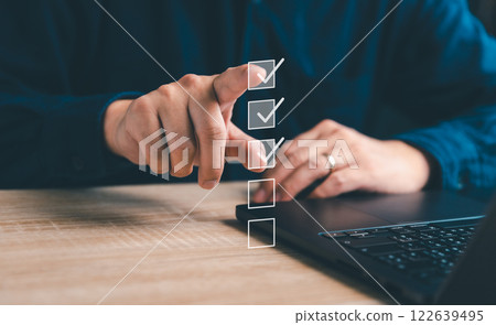 Business performance checklist, businessman using laptop doing online checklist survey, filling out digital form checklist, take an assessment, questionnaire, evaluation, online survey, online exam 122639495