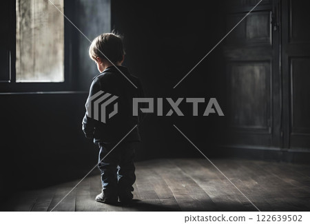 Back view of a boy looking down in a dark house 122639502