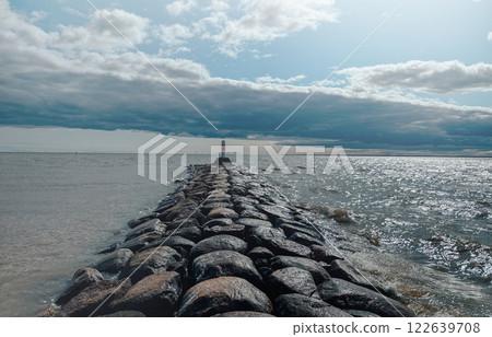 A lighthouse stands on a rock in front of the sea 122639708