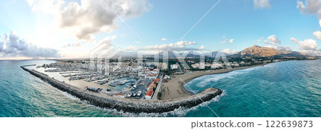 Scenic aerial view of Puerto Banus marina with luxury yachts, beach, and coastal mountains in Scenic aerial view of Puerto Banus marina with luxury yachts, beach, and coastal mountains in 122639873