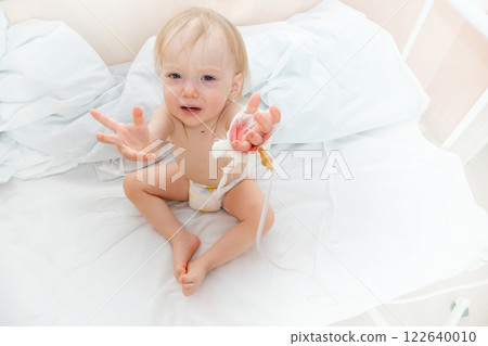 A small child in the hospital asks to be picked up by his mother A small child in the hospital asks to be picked up by his mother 122640010