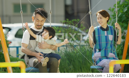 A nursery teacher playing with children in the park 122640183