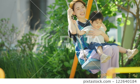 A nursery teacher playing with children in the park 122640184