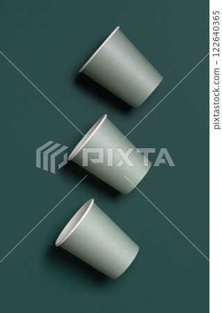 Disposable light green paper cups on a dark green top view, mockup. Sustainable lifestyle 122640365