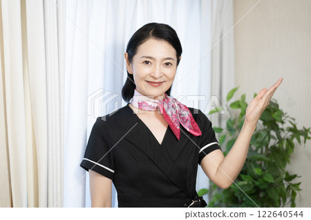 A smiling esthetician woman wearing a black uniform A smiling esthetician woman wearing a black uniform 122640544