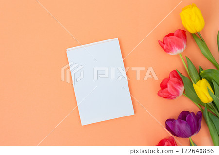 White card on orange background with colorful tulips 122640836