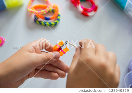 Child Crafting Colorful Loom Bracelets at Home Child Crafting Colorful Loom Bracelets at Home 122640859
