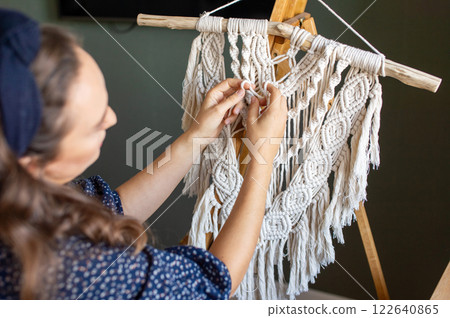 Smiling Woman Crafting Macrame Wall Hanging at Home Smiling Woman Crafting Macrame Wall Hanging at Home 122640865