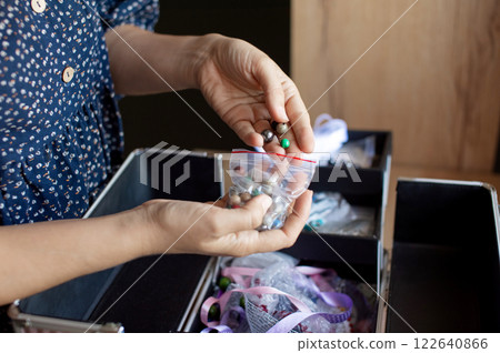 Hand Picking Beads from a Selection for Craft Project 122640866