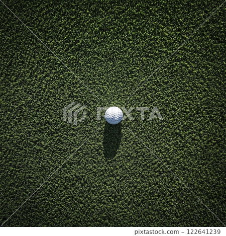 Cinematic view of a golf ball resting on nylon turf with dramatic overhead perspective 122641239