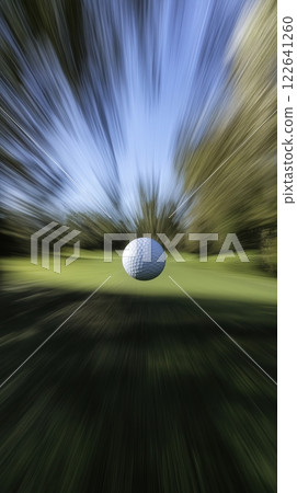 Golf ball speeding through a lush golf course during a vibrant tournament day 122641260