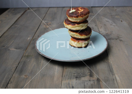 Homemade pancakes, cheesecakes are stacked on a plate on a gray background with space for copyspace text. Homemade breakfast Homemade pancakes, cheesecakes are stacked on a plate on a gray background with space for copyspace text. Homemade breakfast 122641319