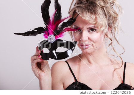 Woman middle aged holds carnival mask. 122642026