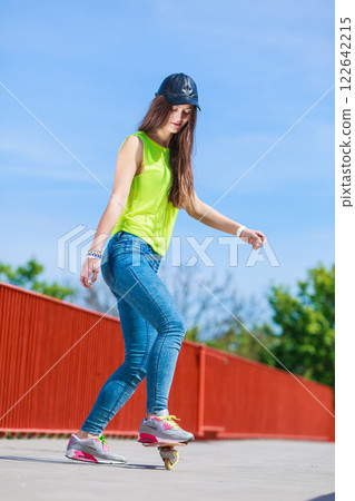 Teen girl skater riding skateboard on street. 122642215