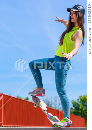 Teen girl skater riding skateboard on street. Teen girl skater riding skateboard on street. 122642219