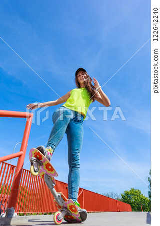 Teen girl skater riding skateboard on street. Teen girl skater riding skateboard on street. 122642240