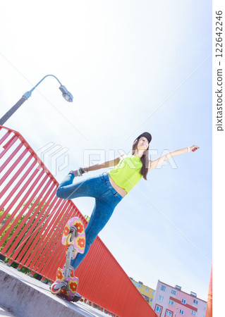 Teen girl skater riding skateboard on street. 122642246