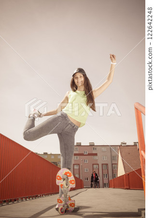 Teen girl skater riding skateboard on street. 122642248