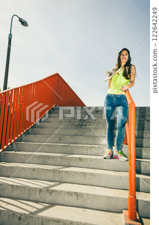 Girl on stairs with skateboard. 122642249