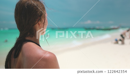 Woman enjoying a tropical vacation on phi phi islands in thailand, soaking up the sun, sand, and crystal-clear waters. 4K slow motion video Woman enjoying a tropical vacation on phi phi islands in thailand, soaking up the sun, sand, and crystal-clear waters. 4K slow motion video 122642354