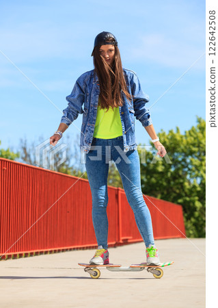 Summer sport. Cool girl skater riding skateboard 122642508