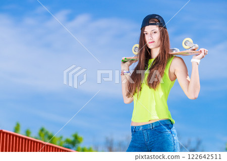 Teenage girl skater riding skateboard on street. Teenage girl skater riding skateboard on street. 122642511