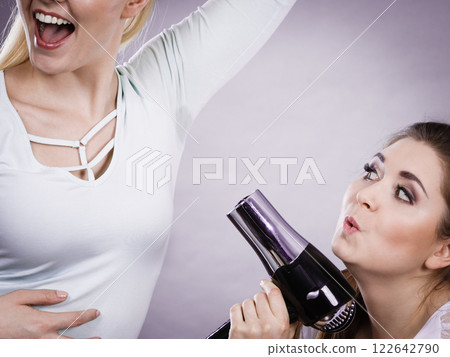 Woman using dryer drying her friend wet armpit Woman using dryer drying her friend wet armpit 122642790