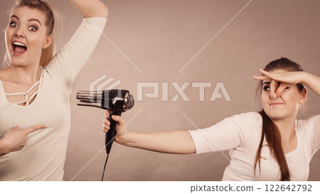Woman drying friend armpit with hair dryer Woman drying friend armpit with hair dryer 122642792