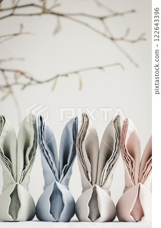 Easter bunny ear made from linen napkins against white backdrop with place for text. 122643396