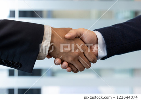 Handshake between two business professionals symbolizing partnership and agreement, fostering trust and collaboration in office environment. Represents successful deal and professional connection. 122644074