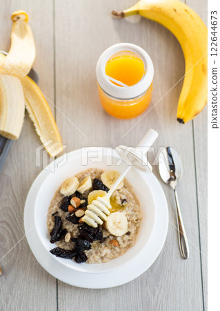 Healthy oatmeal with banana, nuts and prunes Healthy oatmeal with banana, nuts and prunes 122644673