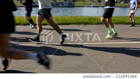 Motion blurred marathon runners in a city. Group of marathon runners compete in the race outdoors Motion blurred marathon runners in a city. Group of marathon runners compete in the race outdoors 122645268