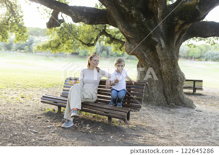 Mother and son sharing a moment together on a park bench 122645286