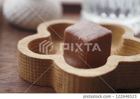 A delicious chocolate cube elegantly placed in a wooden tray on the table 122646523