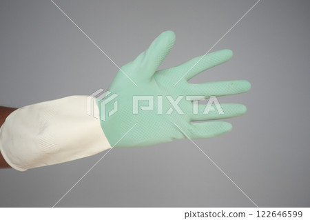 Green rubber glove on a hand for various tasks Green rubber glove on a hand for various tasks 122646599