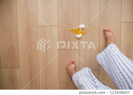 A childs tiny footsteps are seen next to a broken egg lying on the kitchen floor A childs tiny footsteps are seen next to a broken egg lying on the kitchen floor 122646607