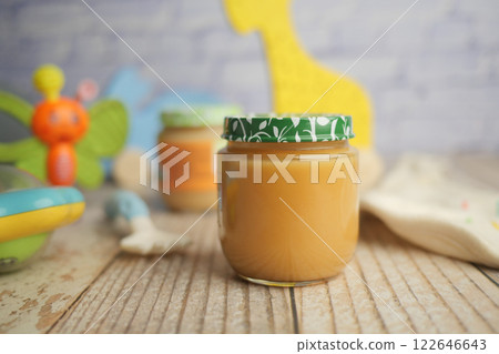 Baby food jars on wooden table with toys Baby food jars on wooden table with toys 122646643