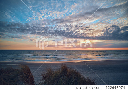 Sunset behind clouds at the north sea coast in Denmark Sunset behind clouds at the north sea coast in Denmark 122647074