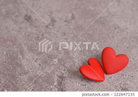 Couple of red earrings heart shape on a gray concrete background. Copy space background, cover, backdrop, texture. Place for adding text or design. Blood donor donation 122647135